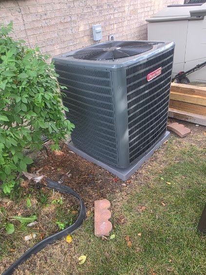 Air-conditioning condenser beside a home